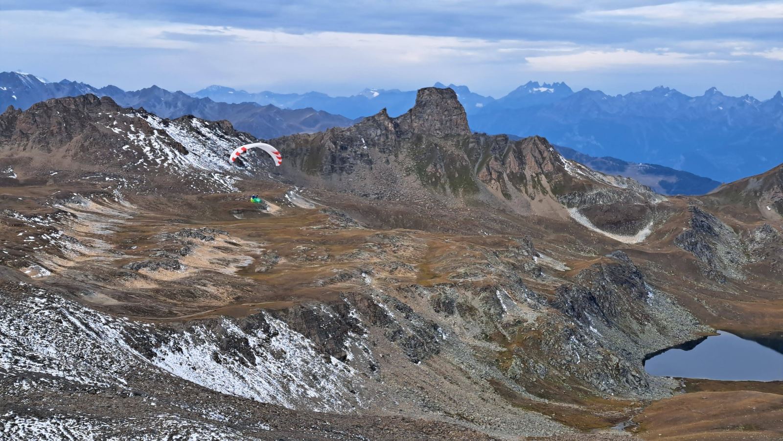 Une voile au loin au-dessus de lacs alpins.