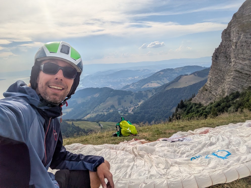 Cédric au décollage, la voile étalée devant une falaise calcaire.